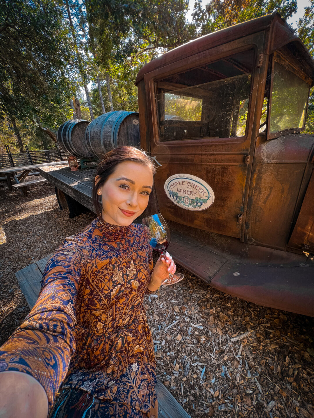 Travel Blogger Jordan Gassner taking a selfie with a glass of wine. infront of a vintage truck at Maple Creek Winery in California's Mendocino County