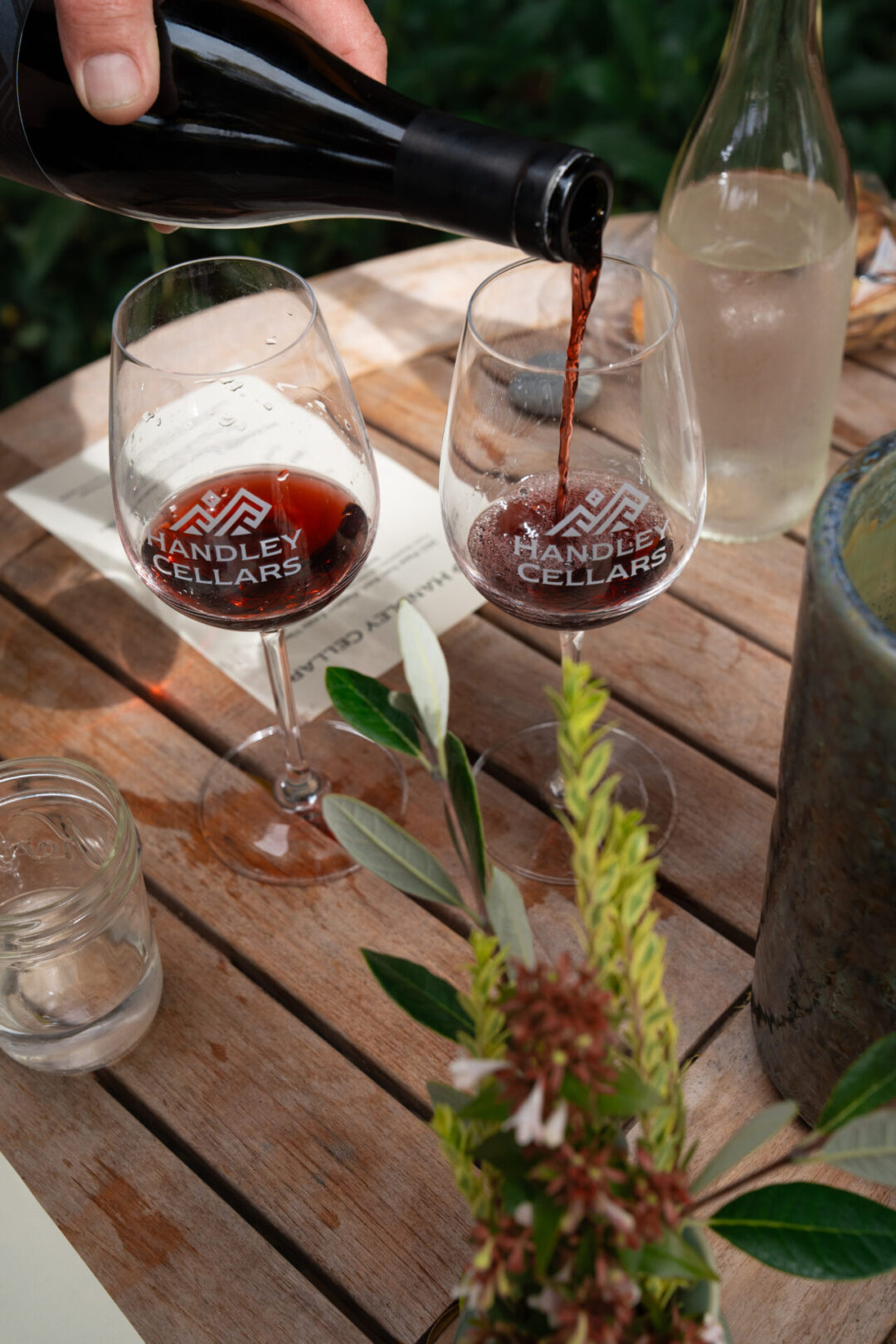 A tasting associate pouring two glasses of "Handley Cellars"-labeled wine at a tasting in California's Anderson Valley