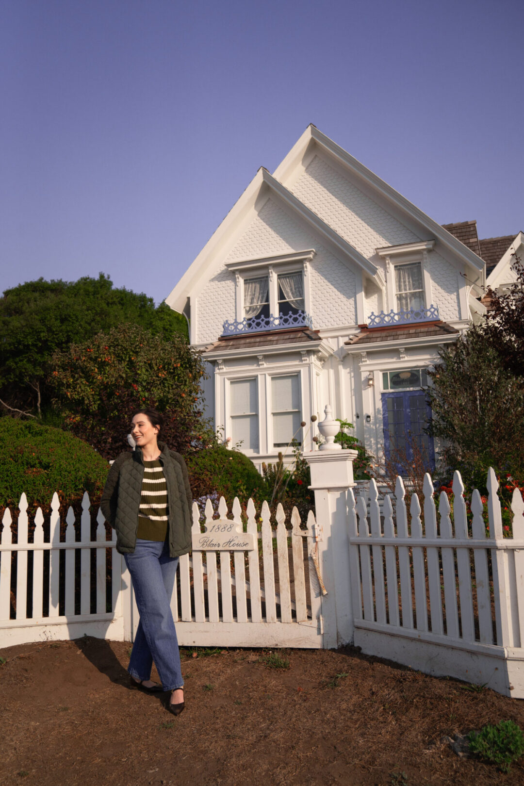 Travel Blogger Jordan Gassner smiling near the the Blair House Inn Gate in Mendocino, California