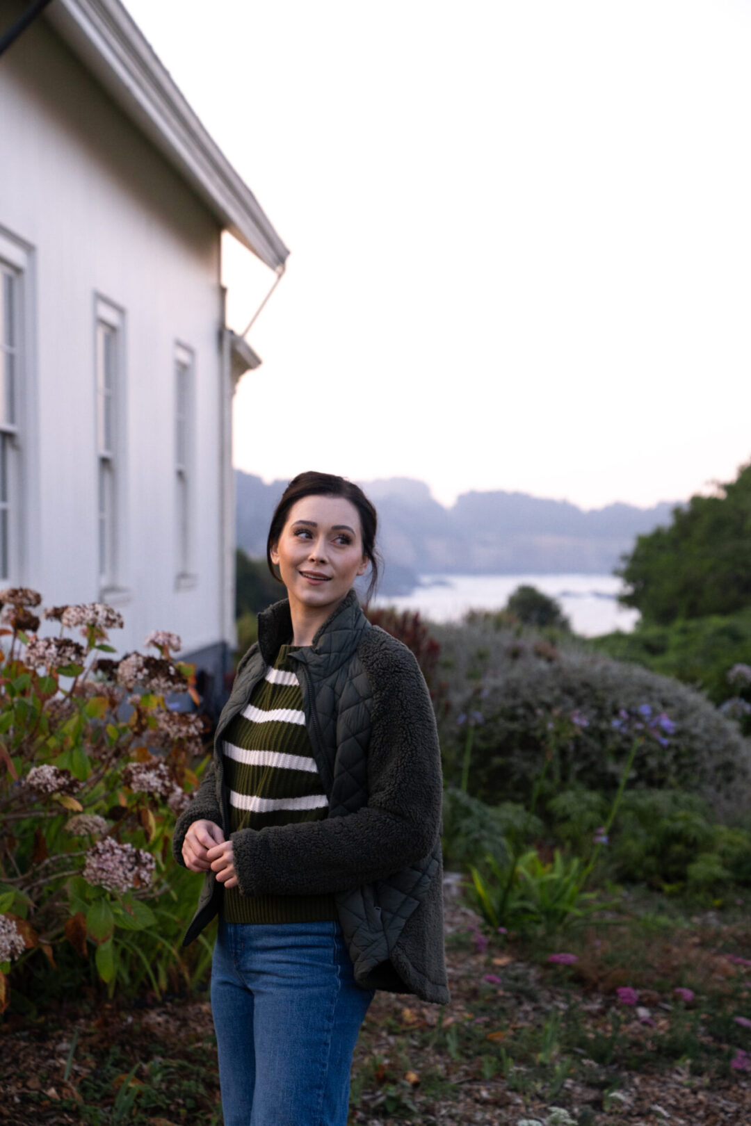 Travel Blogger Jordan Gassner smiling during sunrise outside the historic Ford House in Mendocino, California