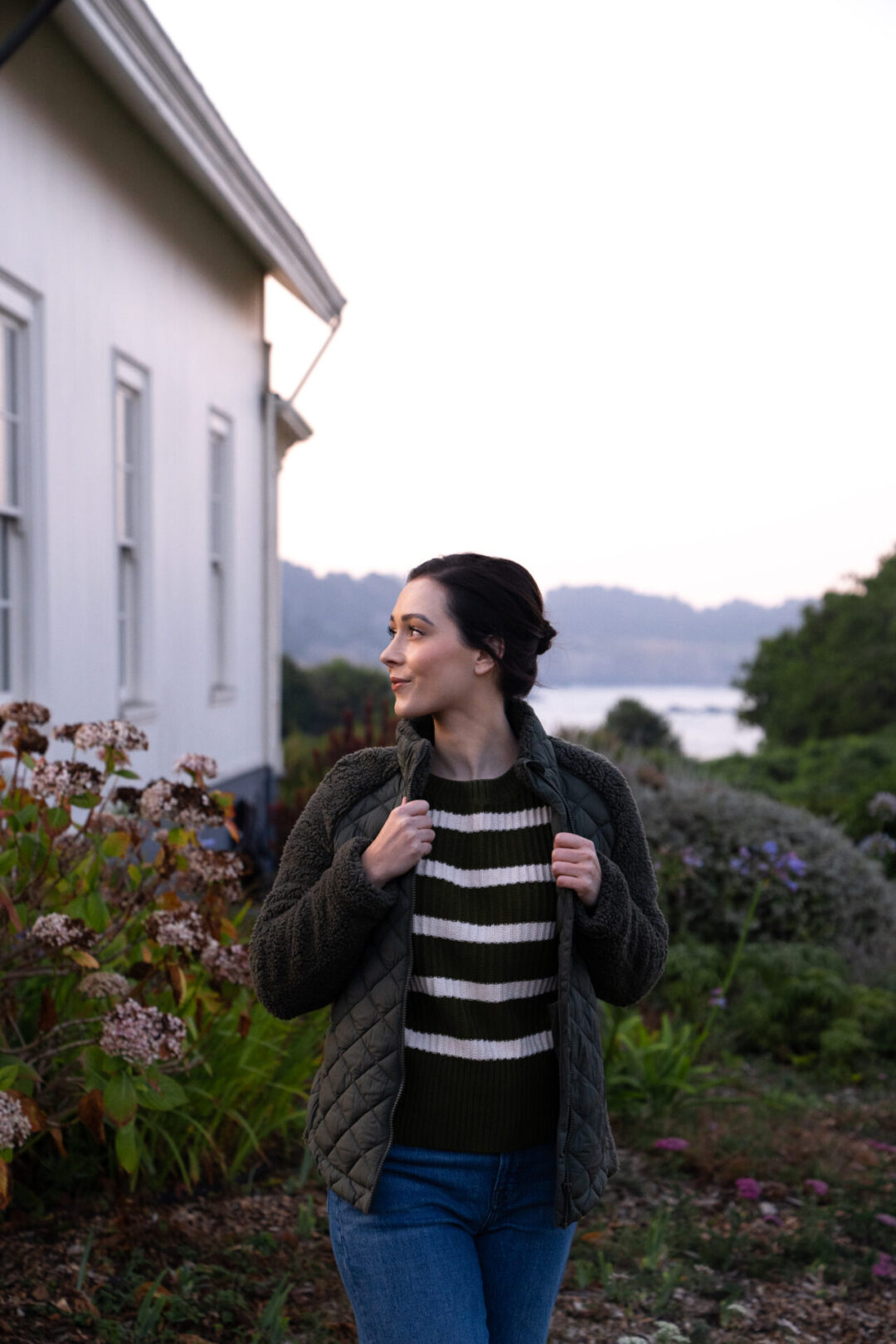 Mendocino Travel Guide: Travel Blogger Jordan Gassner adjusting her coat outside the historic Ford House in Mendocino, California