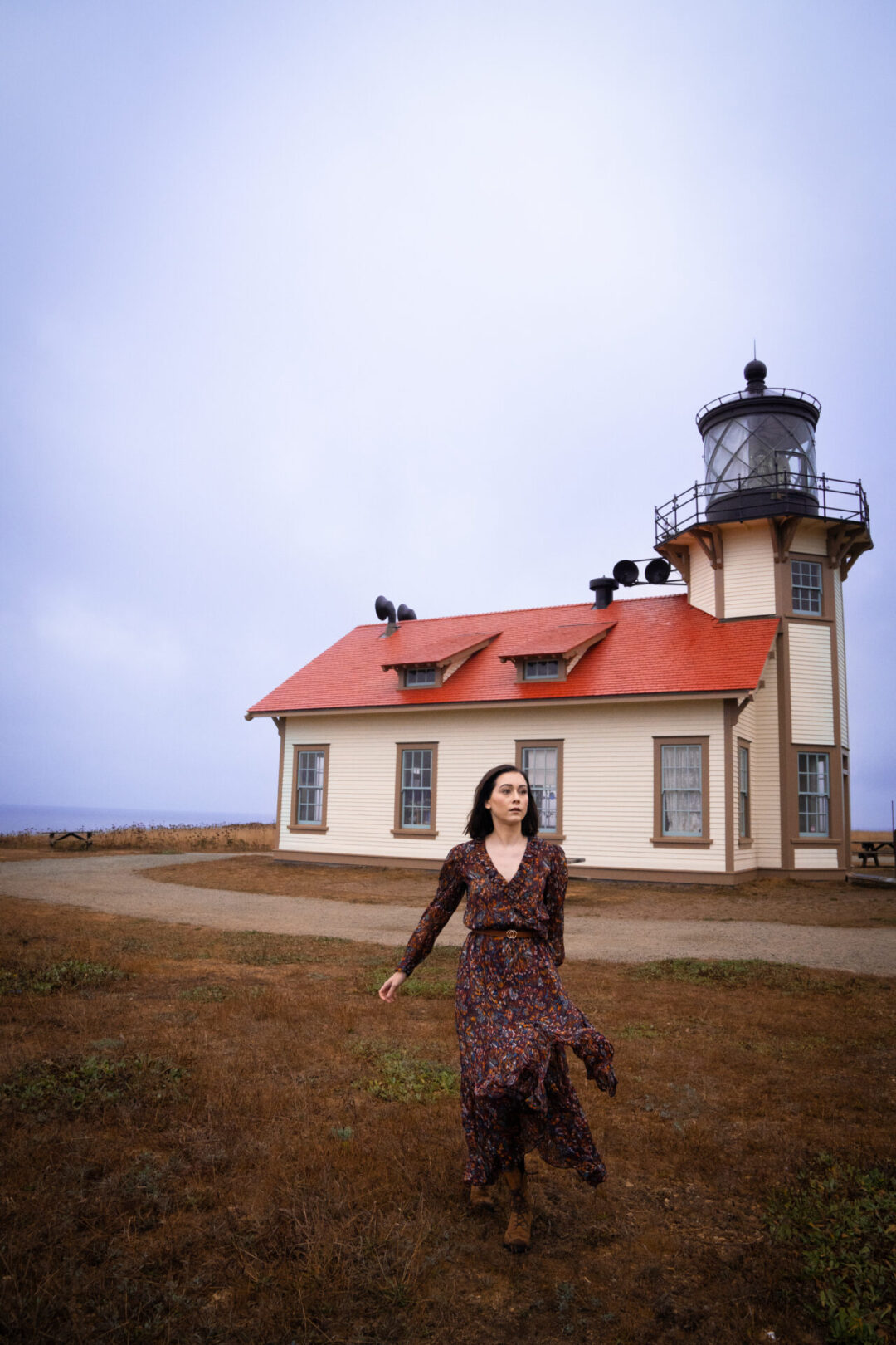 Travel Blogger Jordan Gassner twirling in front of the Point Cabrillo Light Station along the Northern California coast