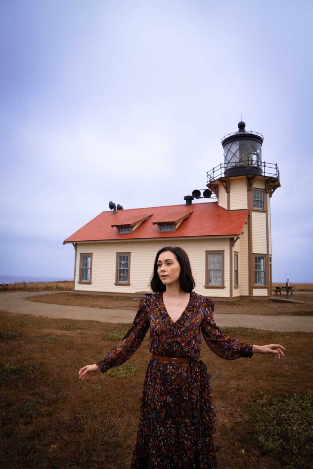 Travel Blogger Jordan Gassner twirling in front of Point Cabrillo Lighthouse along the Northern California coast