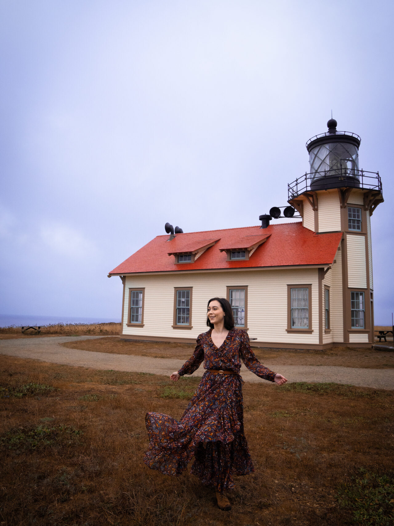 Travel Blogger Jordan Gassner dancing in the wind in front of Point Cabrillo Lighthouse near Mendocino and Fort Bragg, California