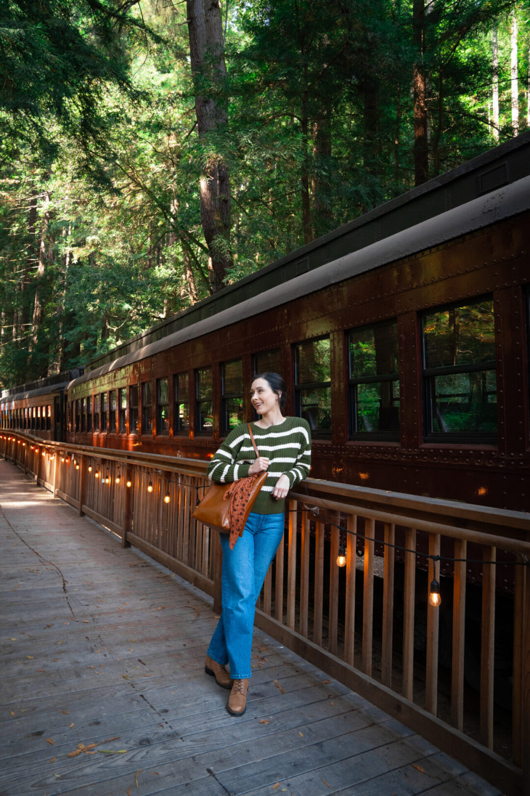 Travel Blogger Jordan Gassner leaning against the Skunk Train platform at Glen Blair Bar in Fort Bragg, California