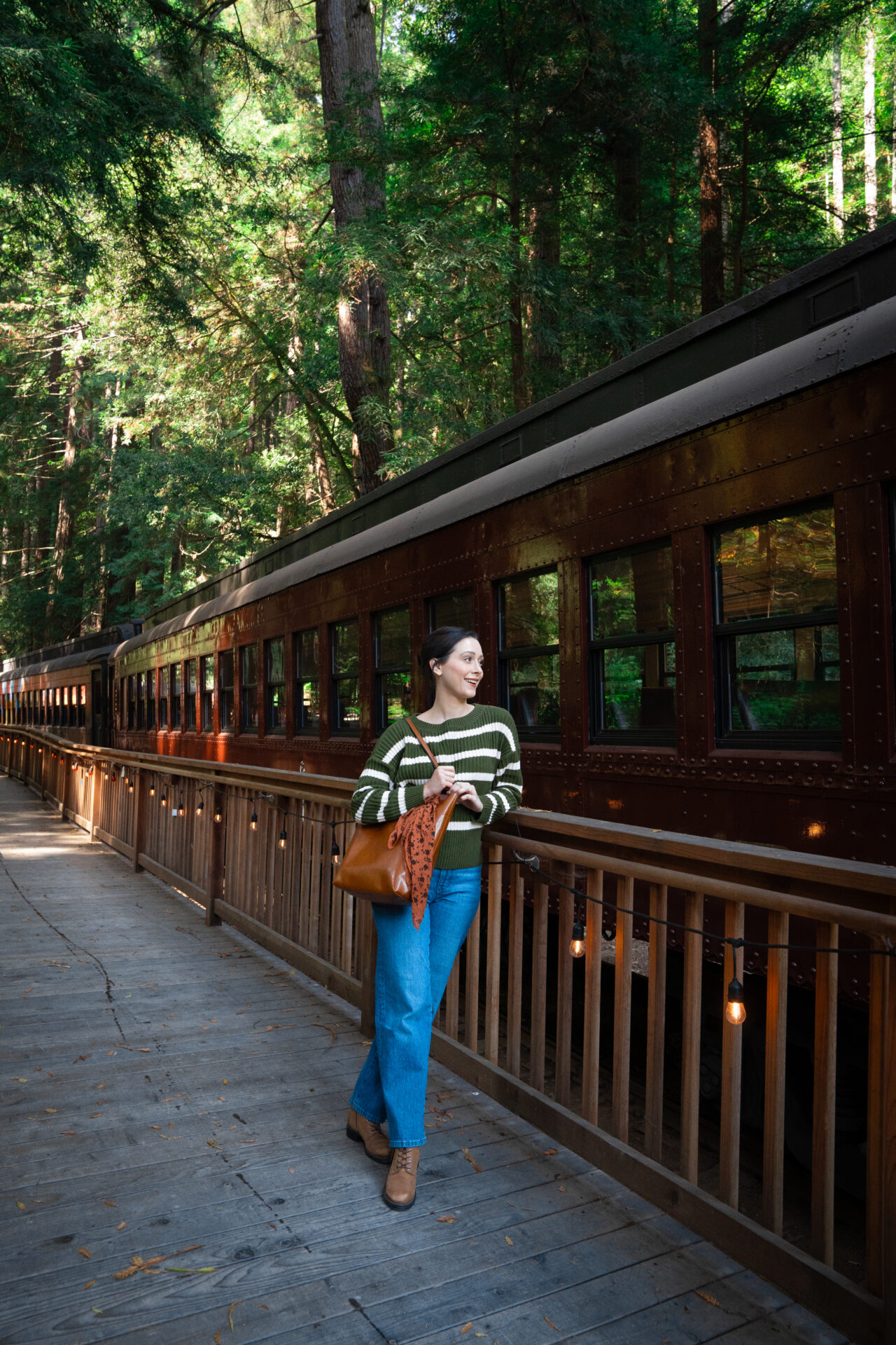 Travel Blogger Jordan Gassner leaning against a railing on the Skunk Train Platform in Mendocino, California