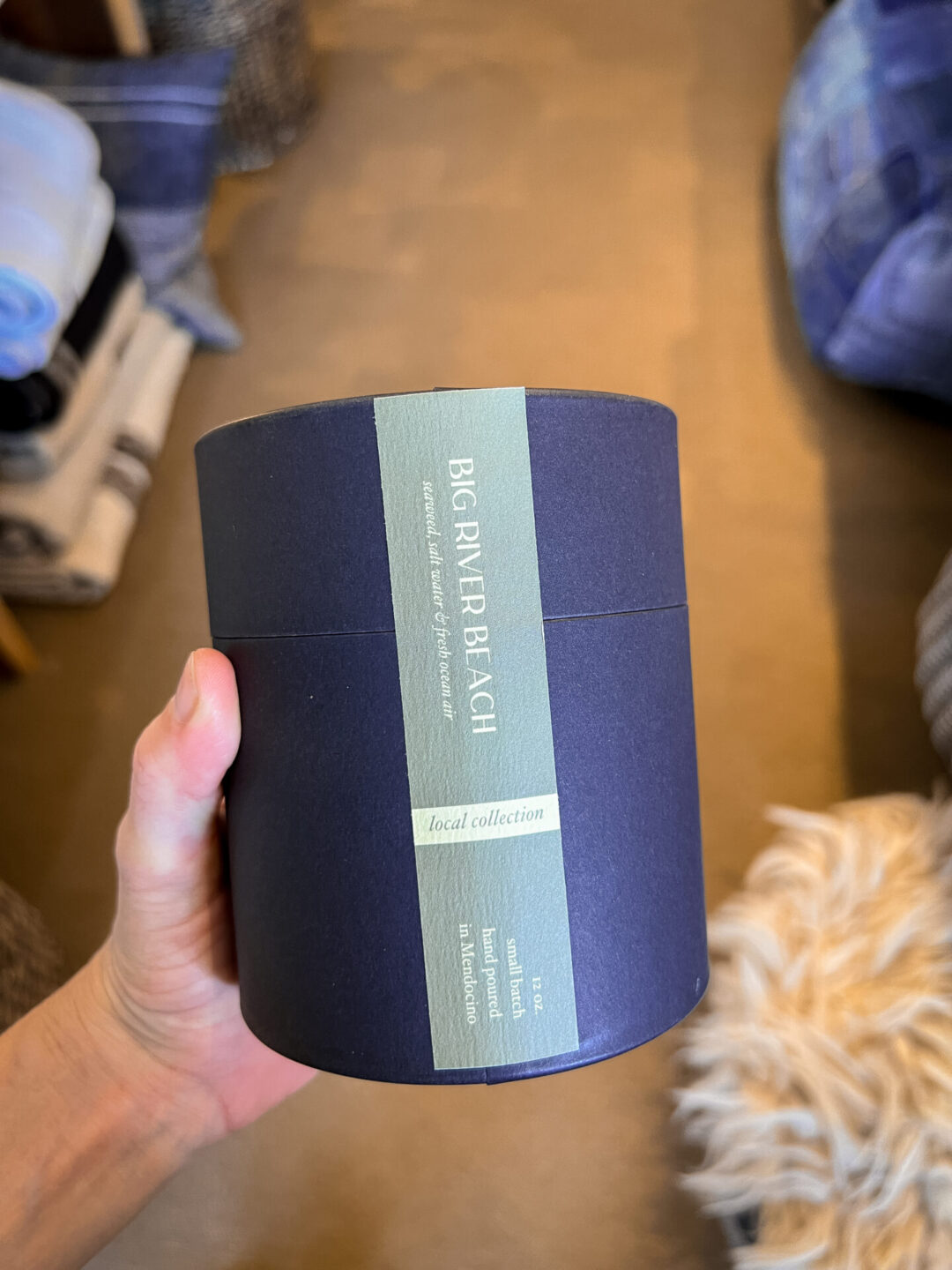 Travel Blogger Jordan Gassner holding a Mendocino Candle Co scent inside The Study Club boutique in Mendocino, California