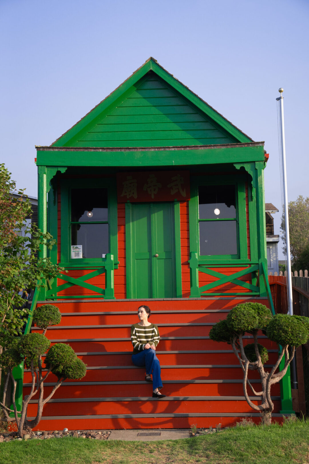 Travel Blogger Jordan Gassner sitting along the steps at Temple of Kwan Tai in Mendocino, California
