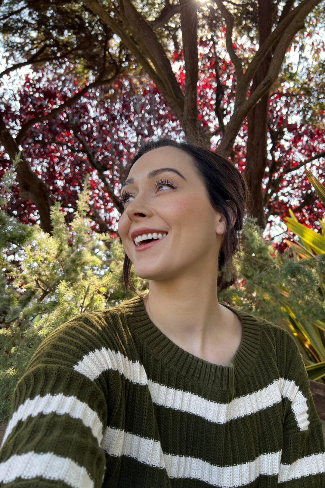 Travel Blogger Jordan Gassner taking a selfie under the autumn leaves at The Brickery Pizzeria in Mendocino, California