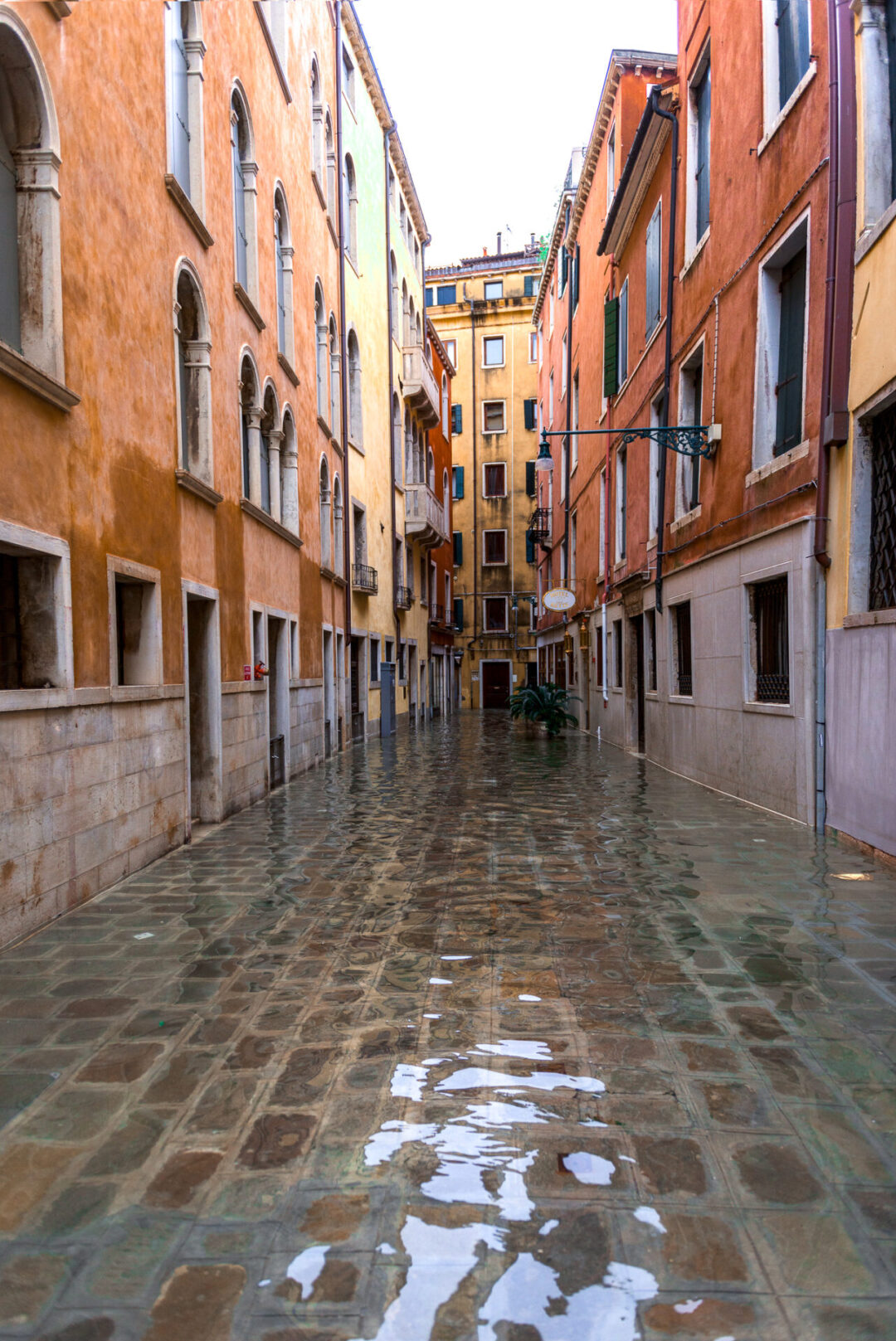 A random and colorful cobblestone street in Venice, Italy under acqua alta flooding