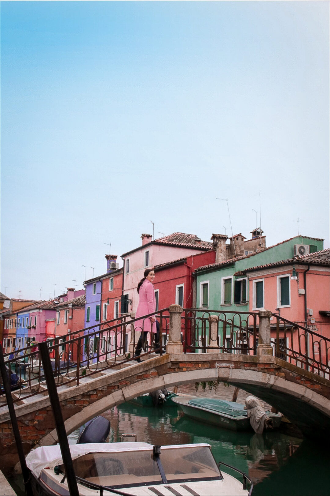 Travel Blogger Jordan Gassner crossing a bridge over a canal in coloful Burano near Venice, Italy
