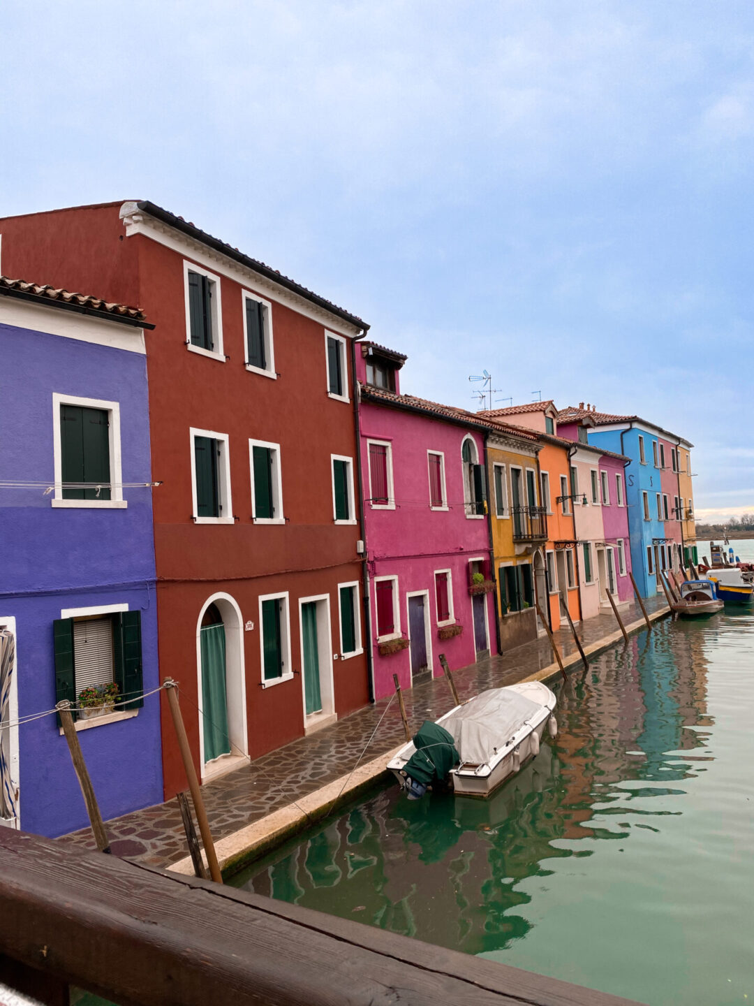 A colorful row of buildings alongside a canal in Burano, Italy