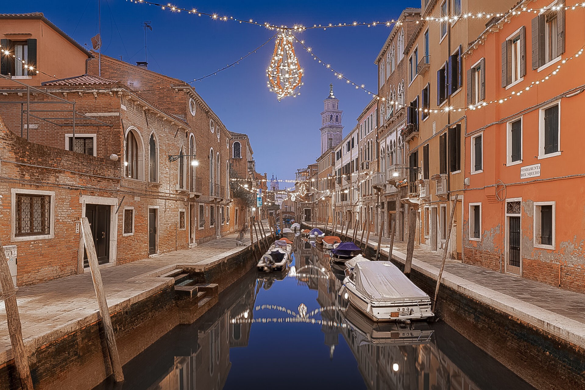 Christmas lights twinkling over a wide canal in Venice, Italy