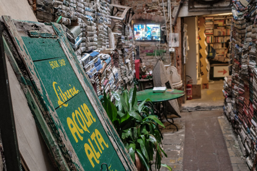 A green and yellow sign at Libreria Acqua Alta, a bookstore in Venice, Italy.