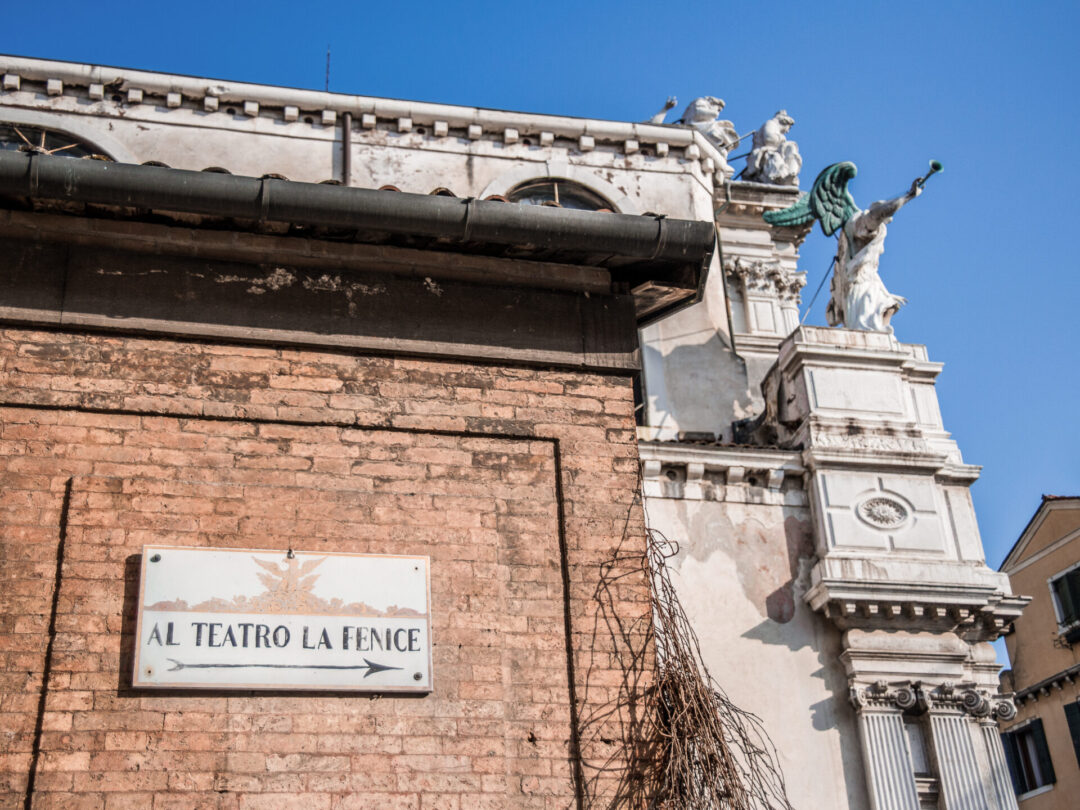 A street sign pointing toward La Fenice Opera House in Venice, Italy