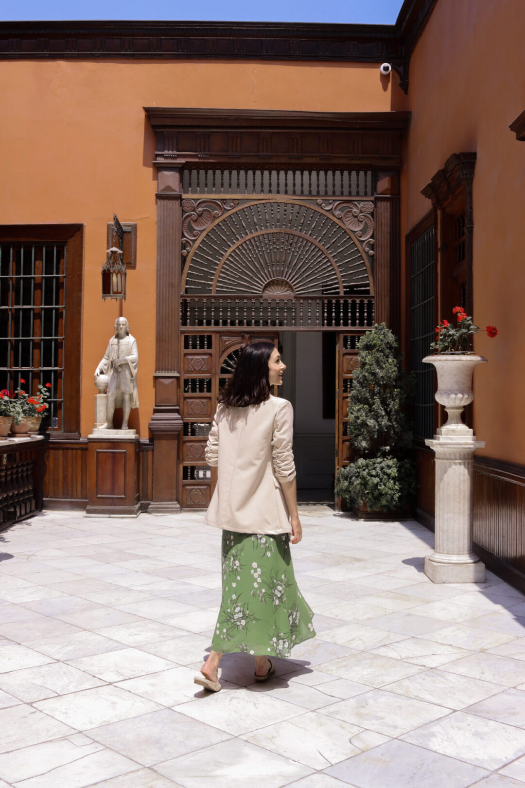 Travel Blogger Jordan Gassner walking intothe house from the porch of Casa Aliaga in Lima, Peru