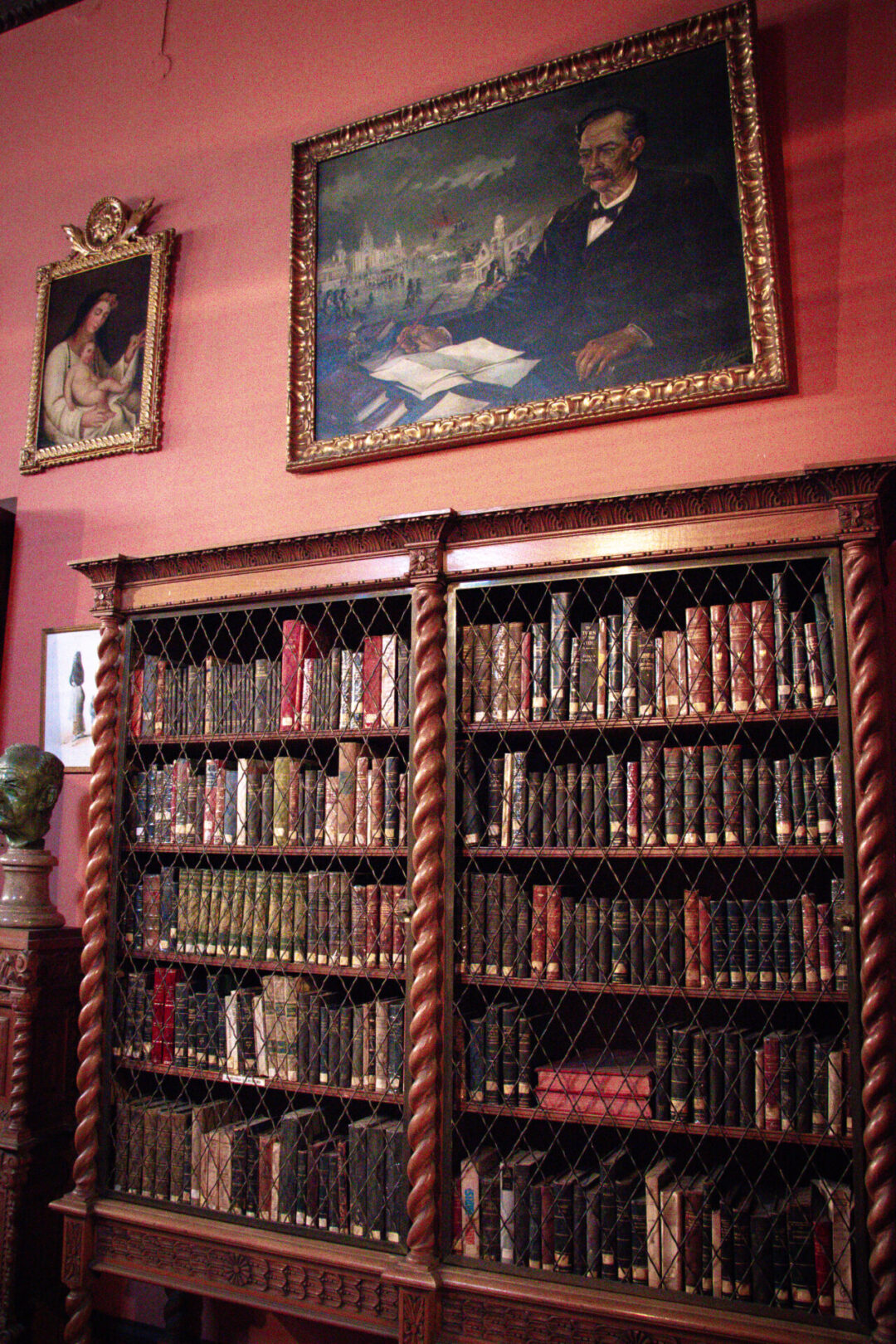 An intricately designed library shelf holding an array of historic books inside Casa de Larriva in Lima, Peru