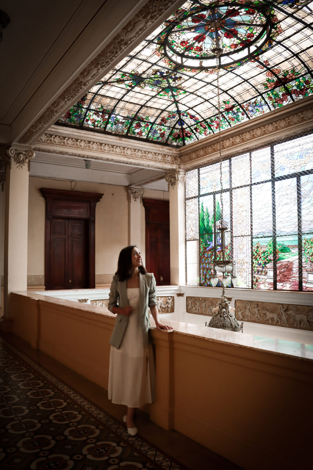 Travel Blogger Jordan Gassner looking up at the colorful stained glass ceiling inside Casa Fernandini one of many historic homes in Lima, Peru