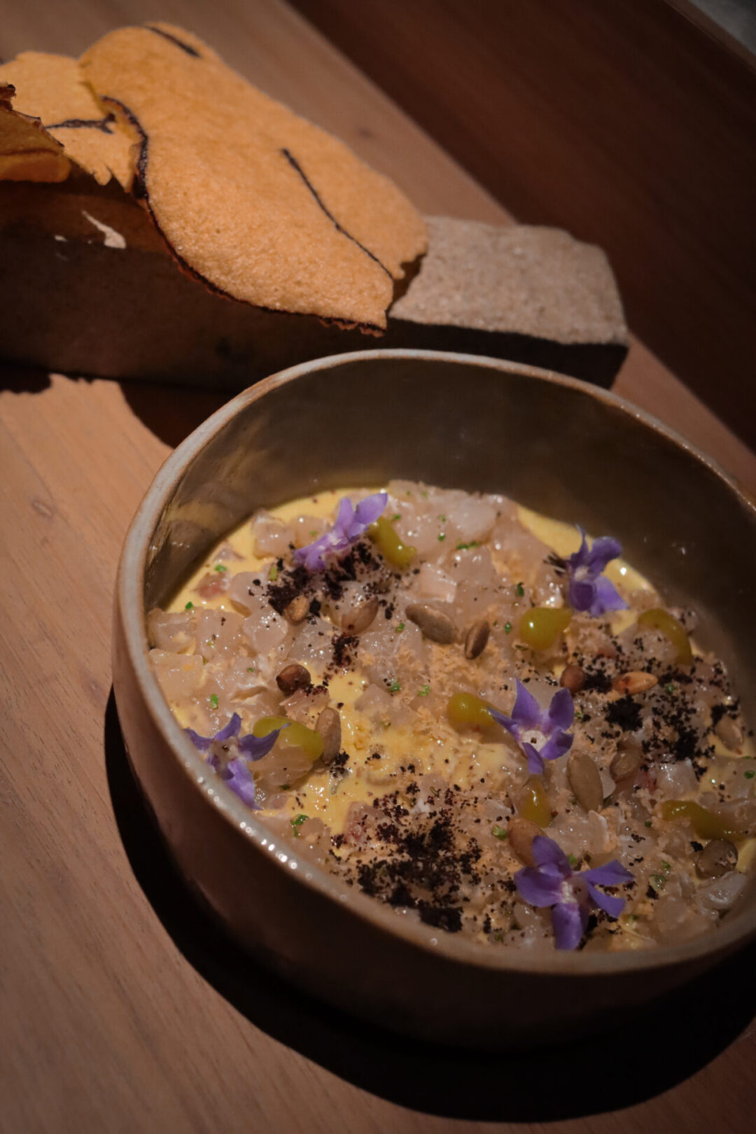 A ceviche dish with edible purple flowers and crackers from Merito in Lima, Peru