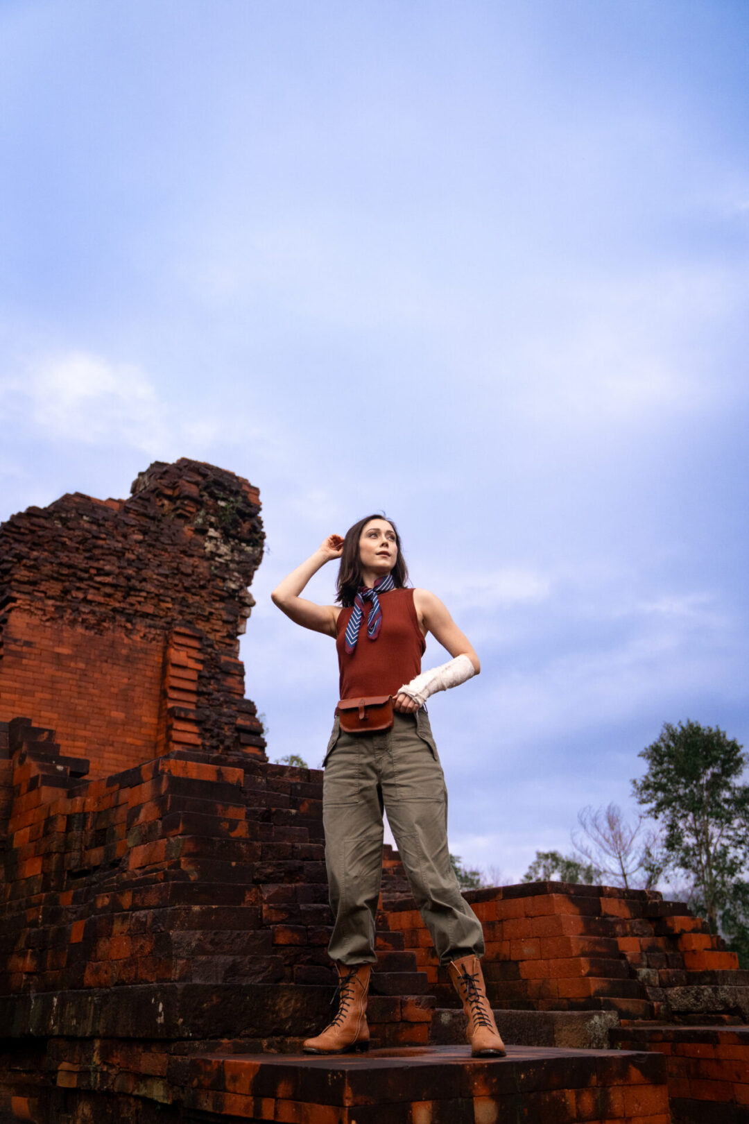Travel Blogger Jordan Gassner looking out and dressed in an explorer outfit while exploring the ancient ruins at MySon near Hoi An, Vietnam