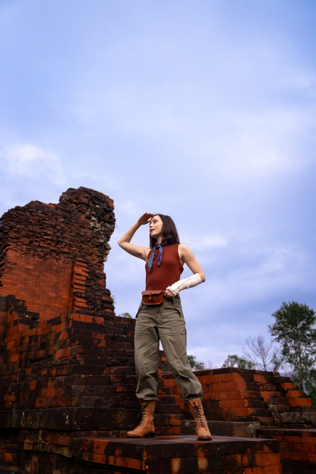 Travel Blogger Jordan Gassner shielding her eyes from the sun while exploring the ancient ruins at MySon near Hoi An, Vietnam