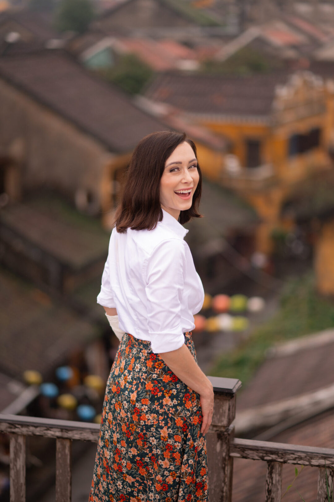 Travel Blogger Jordan Gassner turning around and smiling from a rooftop in Hoi An, Vietnam