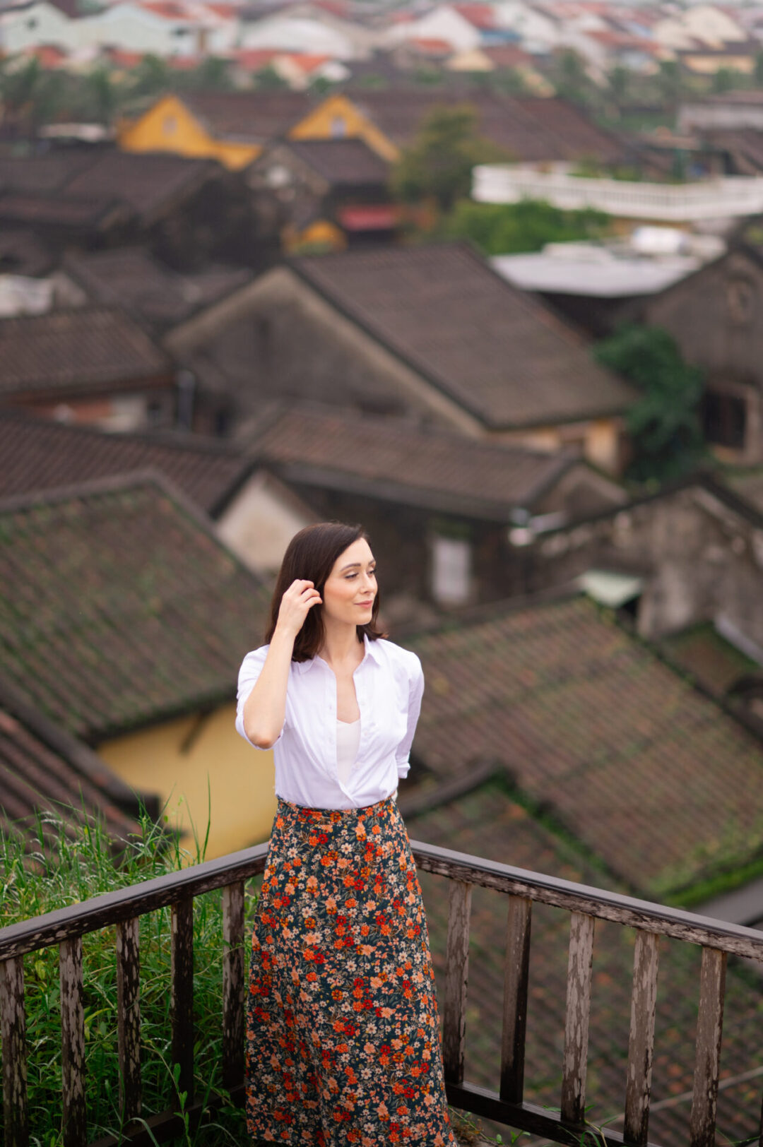 Travel Blogger Jordan Gassner pushing her hair from her face on top of a rooftop in Hoi An, Vietnam
