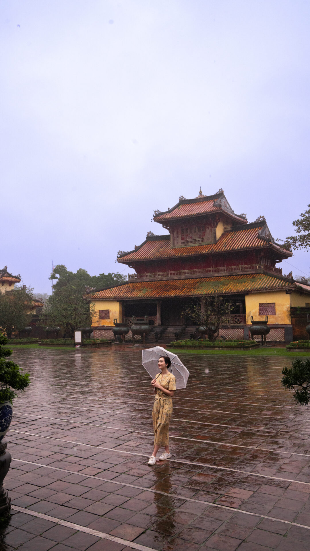 Travel Blogger Jordan Gassner smiling while walking through an empty pavilion inside the historic Imperial City in Hue, Vietnam