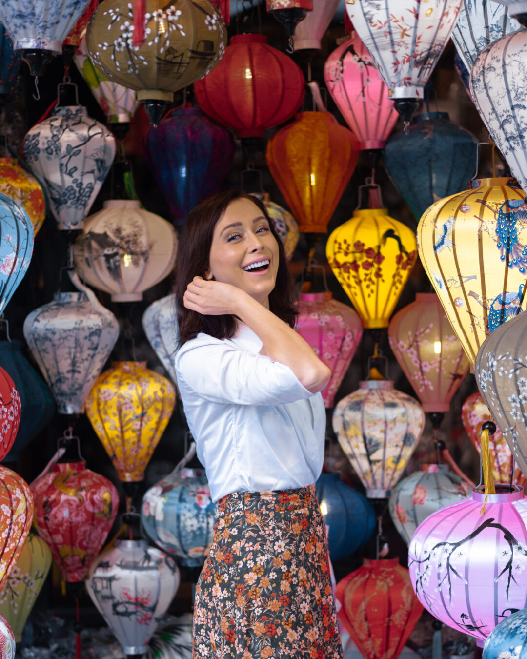 Travel Blogger laughing inside a small lantern shop in Hoi An, Vietnam 