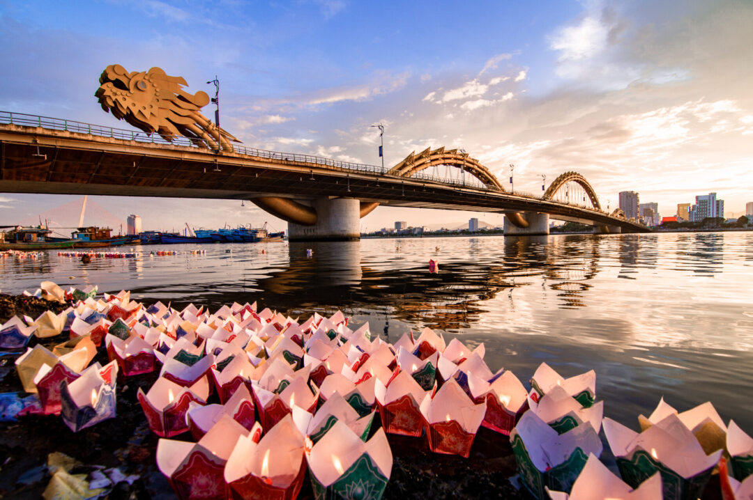  Dragon bridge at sunset, water lanterns floating in the canal just below, in Da Nang Vietnam