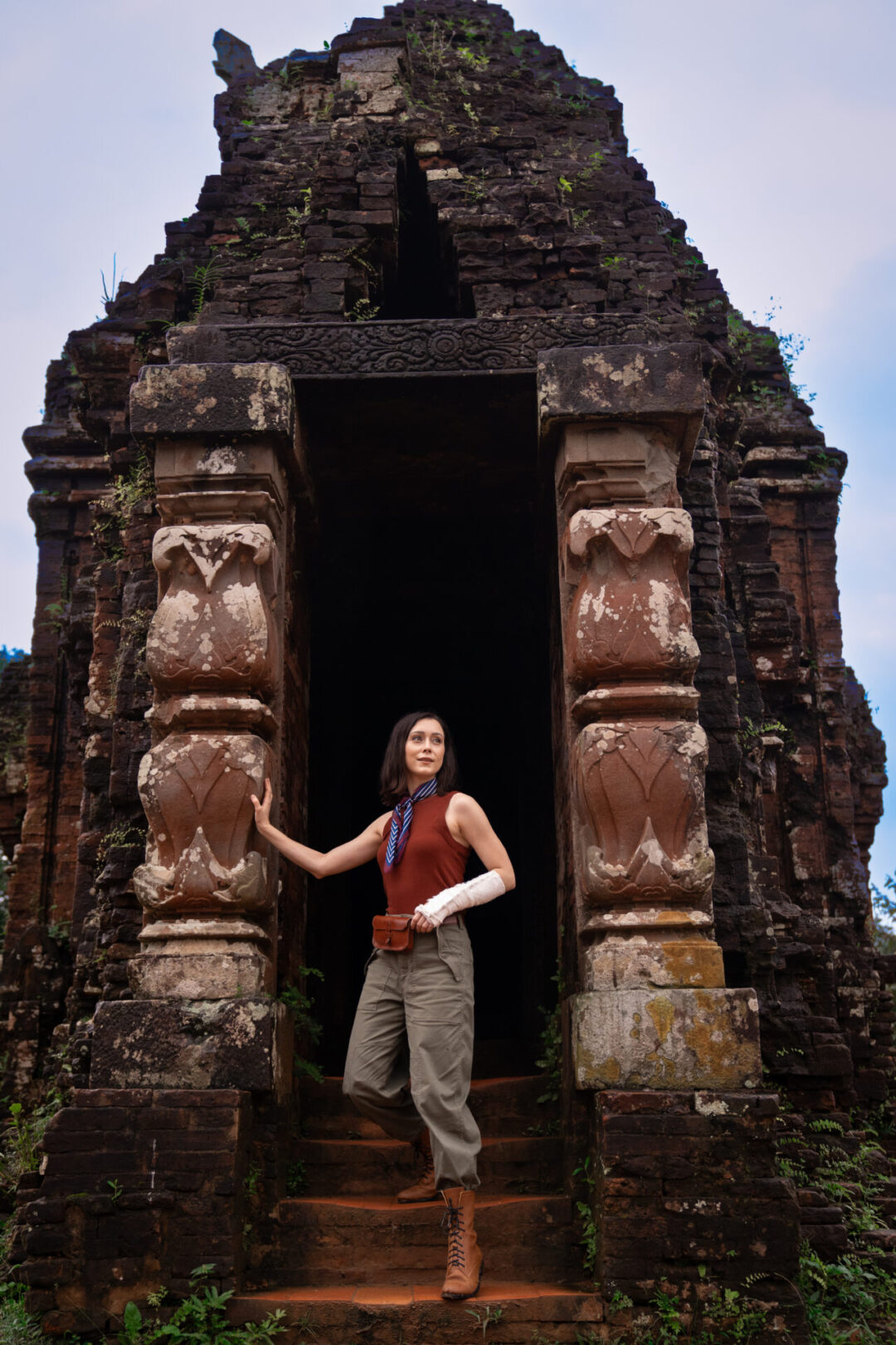 Travel Blogger Jordan Gassner coming down from the steps and entryway of an ancient stone tower at My Son Sanctuary near Hoi An, Vietnam