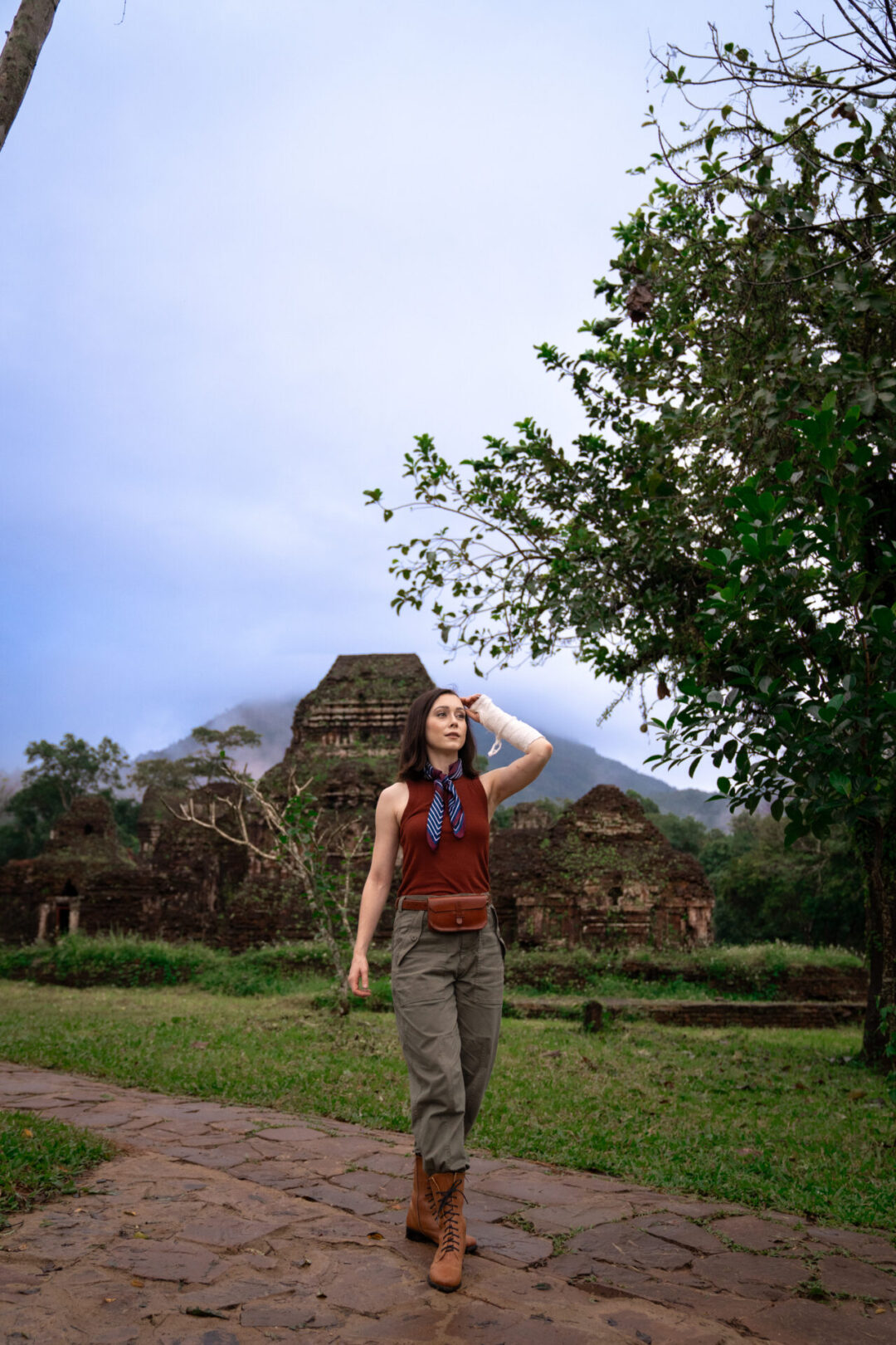 Travel Blogger Jordan Gassner walking along a stone path in front of the My Son Sanctuary ruins