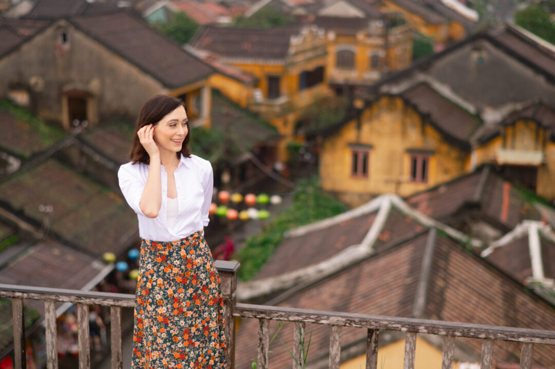 Travel Blogger Jordan Gassner smiling while standing on a rooftop overlooking Hoi An Old Town in Central Vietnam