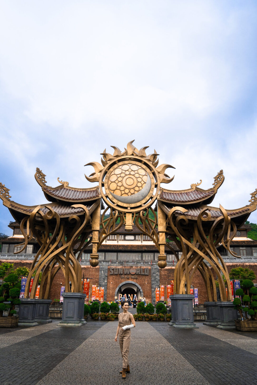 Travel Blogger walking in front of the arch at the entrance to SunWorld Ba Na Hills near Hoi An, Vietnam