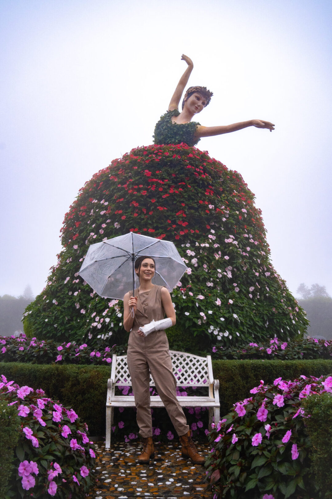 Travel Blogger Jordan Gassner standing in front of a flower ballerina statue in the gardens at SunWorld Ba Na Hills near Hoi An, Vietnam