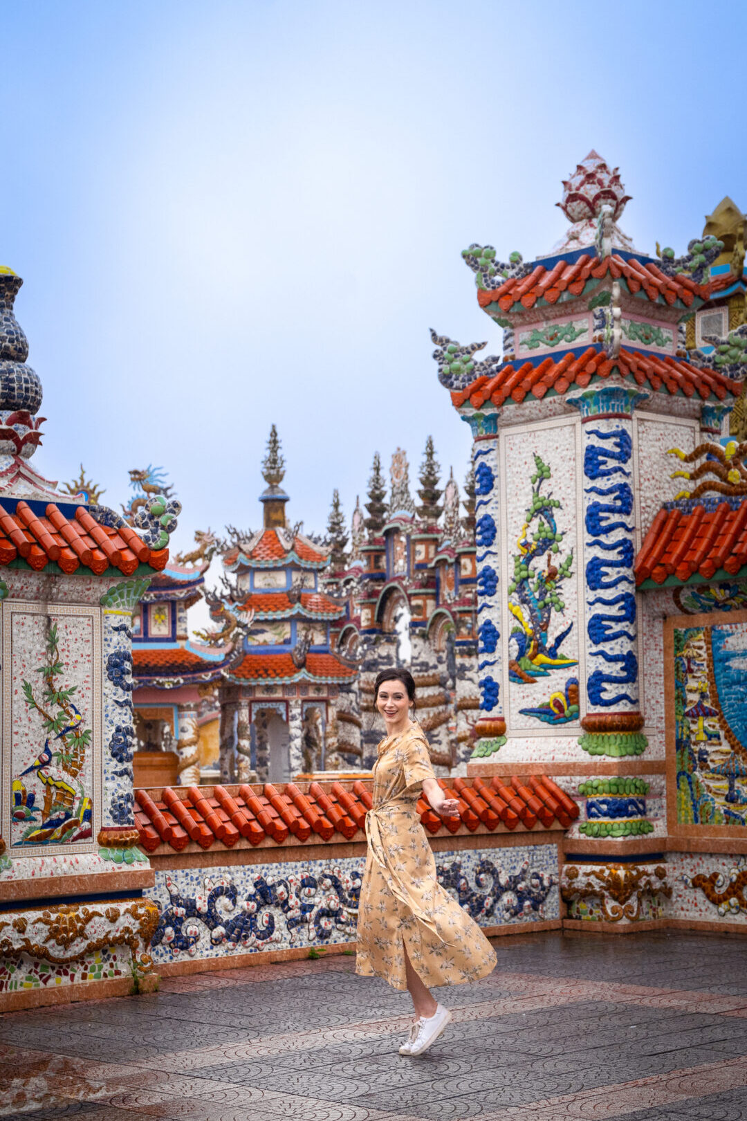 Travel Blogger Jordan Gassner smiling and twirling inside An Bang Cemetery City of Ghosts in Hue, Vietnam