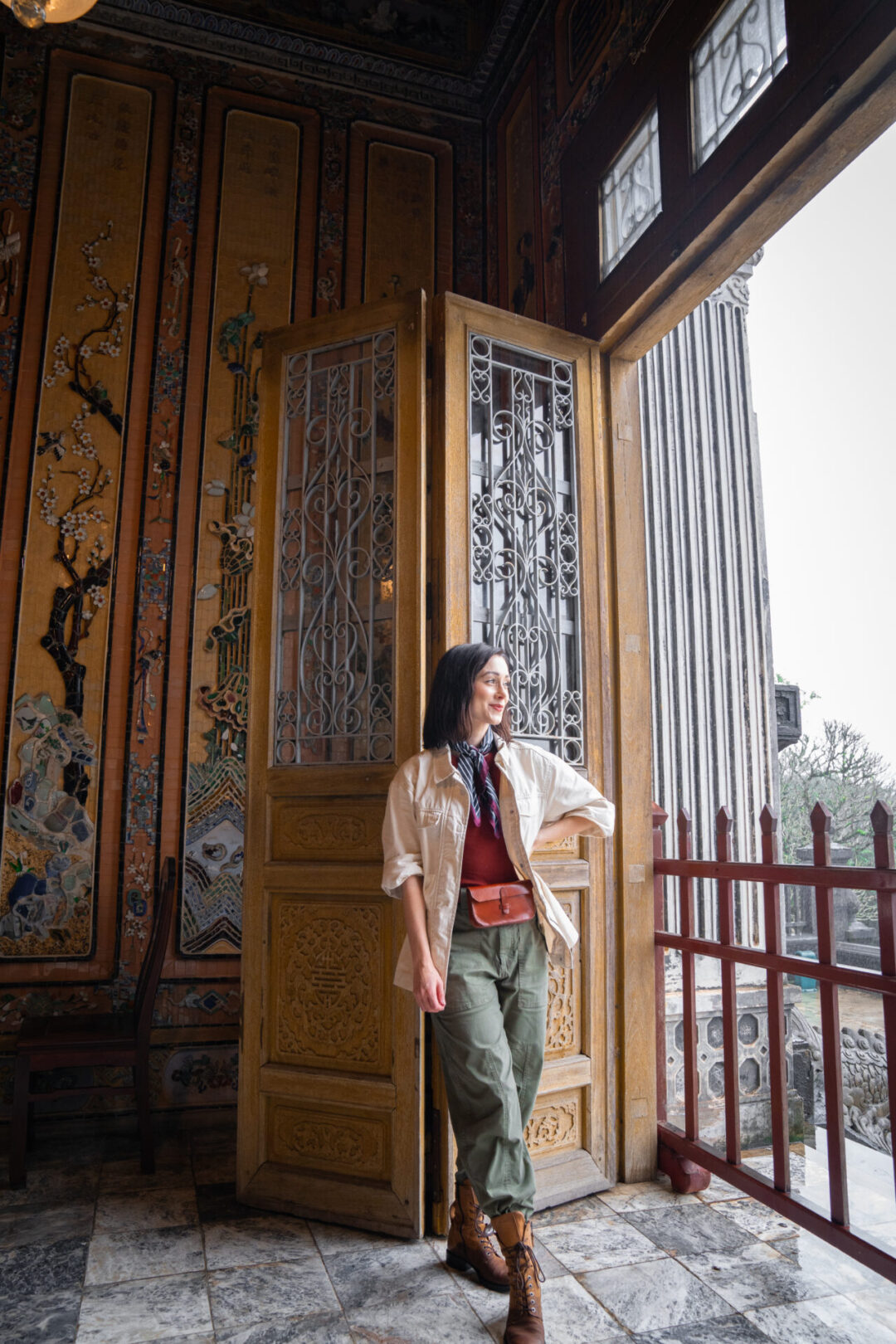 Travel Blogger Jordan Gassner looking out the window and smiling from inside the Tomb of Khai Dinh in Hue, Vietnam