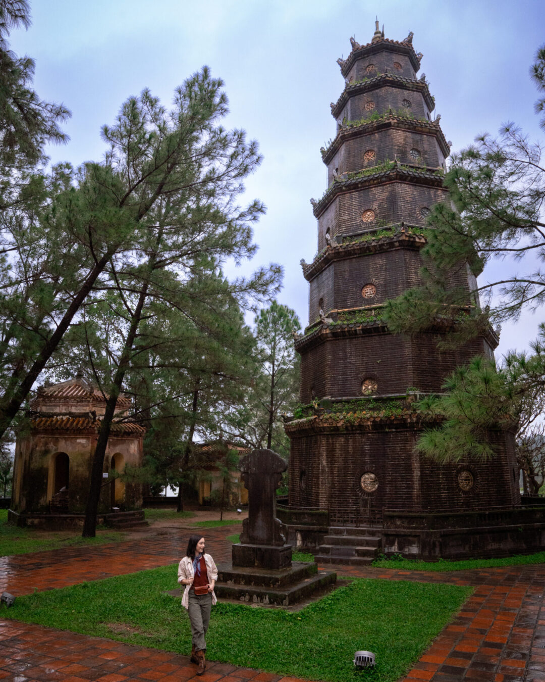 Travel Blogger Jordan Gassner standing at the base of the Thien Mu Pagoda Stupa, the tallest stupa in Vietnam