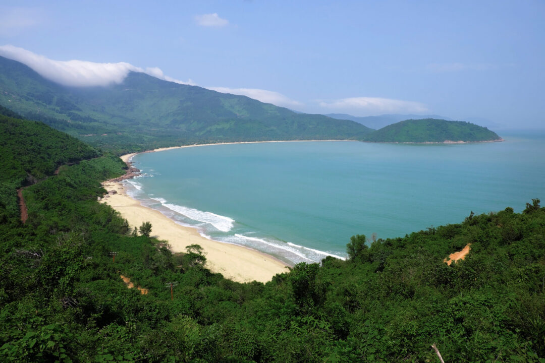 Lang Co Beach in between a lush green forest and a bright blue sea in Vietnam