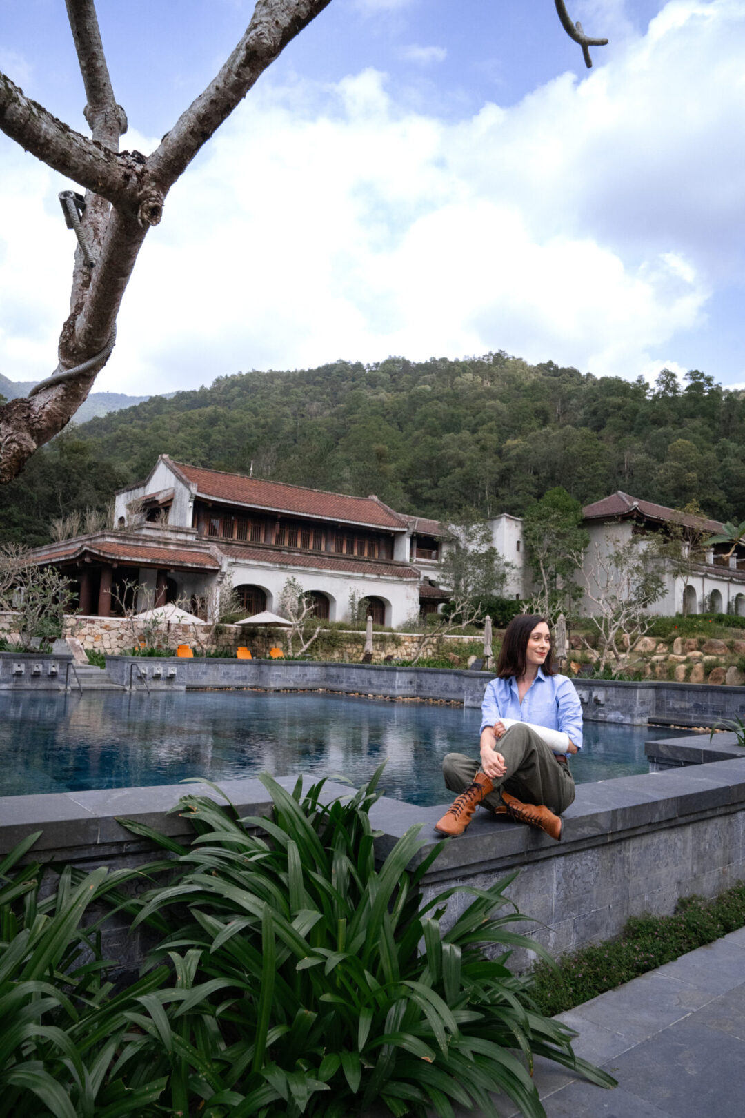 Travel Blogger Jordan Gassner perched near the pool at Legacy Yen Tu Resort in Vietnam