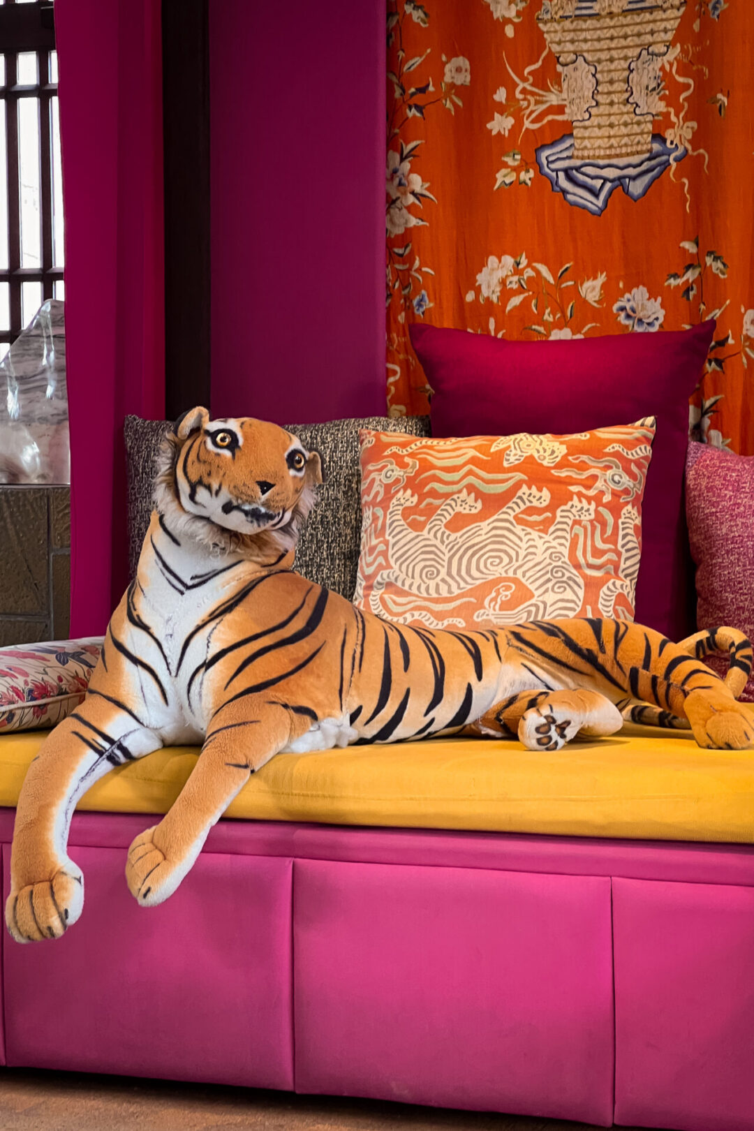 A large tiger plushie sitting on a pink and orange chaise lounge in Legacy Yen Tu - MGallery in Northern Vietnam