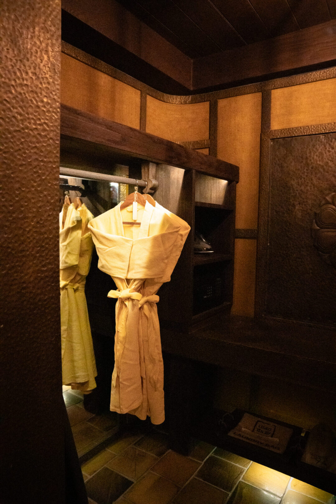 The large walk-in closet inside Legacy Yen Tu Resort, with an iron, scale and two custom robes