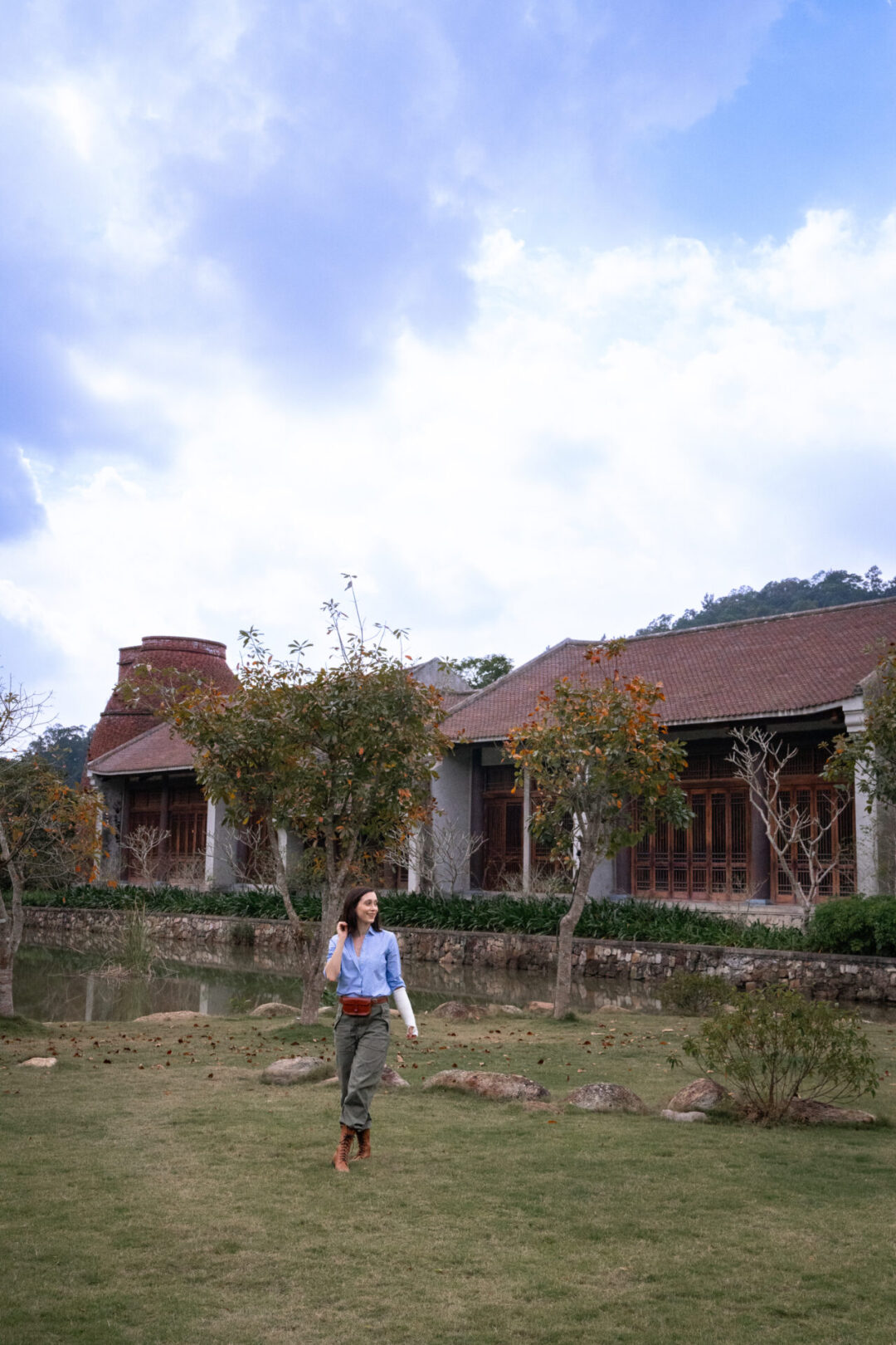 Travel Blogger Jordan Gassner walking on a grassy area in front of Am Tuệ Tĩnh Wellness Center inside Legacy Yen Tu - MGallery in Vietnam