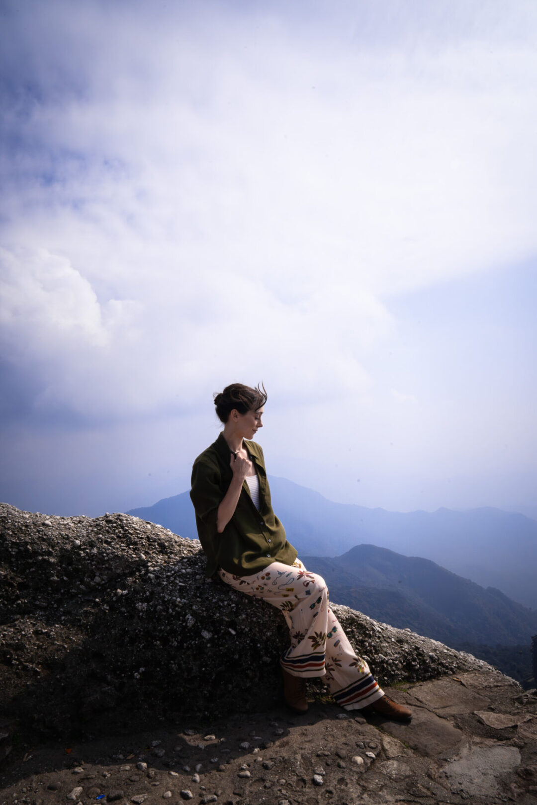 Travel Blogger Jordan Gassner sitting on a mound at the very top of Yen Tu Mountain in Northern Vietnam
