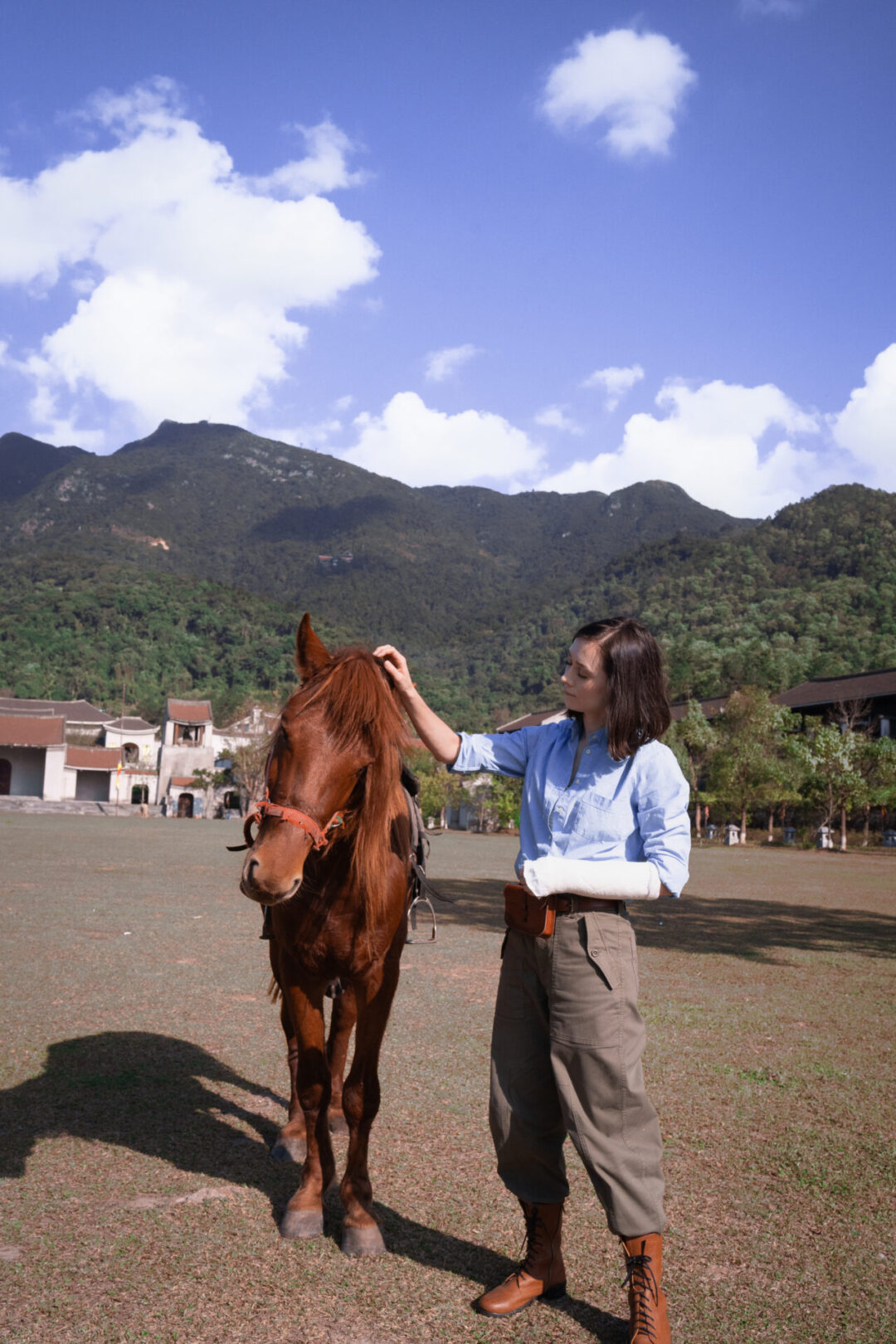 Travel Blogger Jordan Gassner petting a local horse on a field in Yen Tu Village in Vietnam