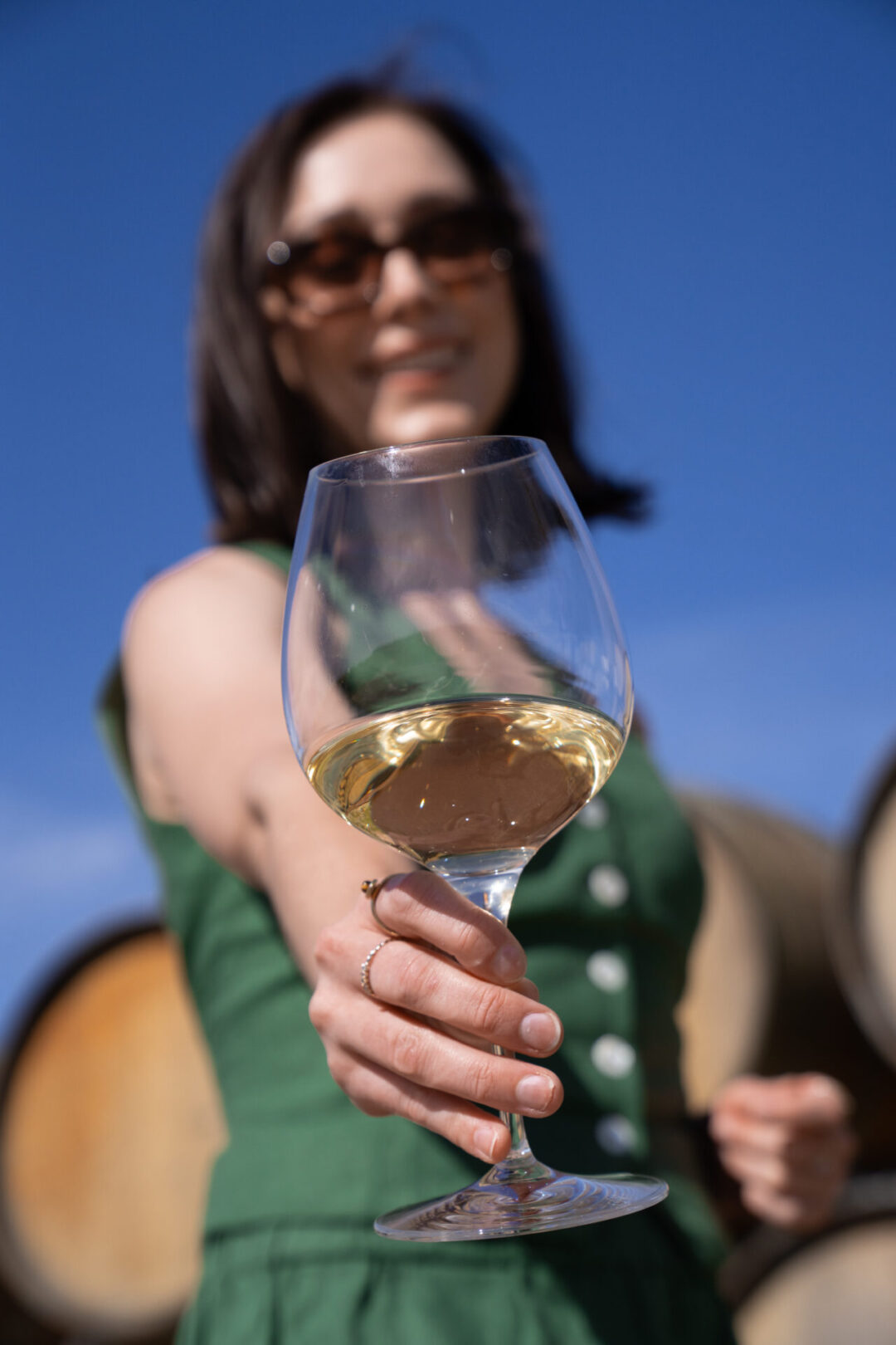 Travel Blogger Jordan Gassner holding up a glass of wine at Chamisal Vineyards in Edna Valley near San Luis Obispo, California