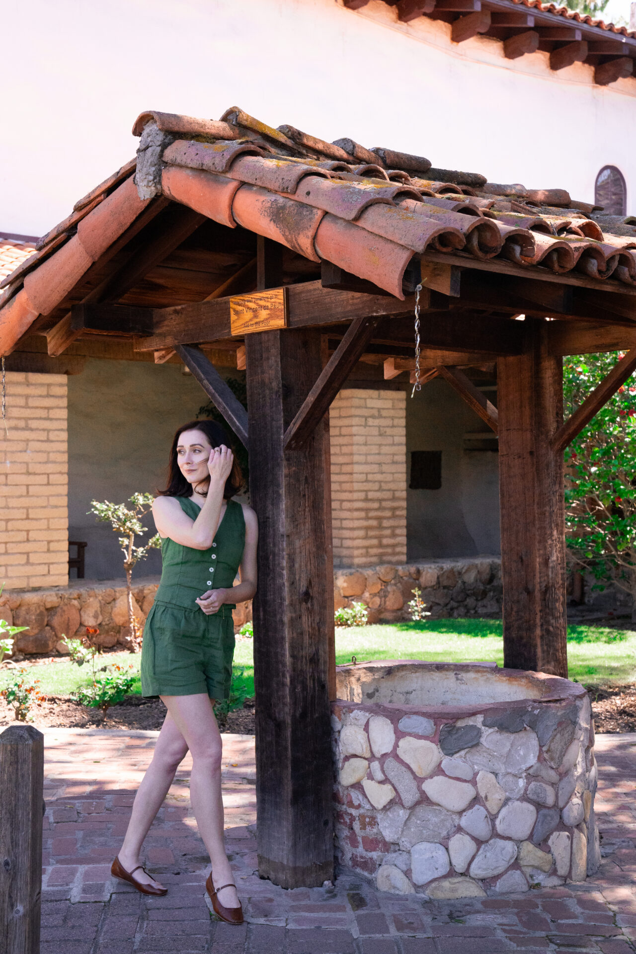Travel Blogger Jordan Gassner standing near a well at Mission San Luis Obispo de Tolosa in Central California