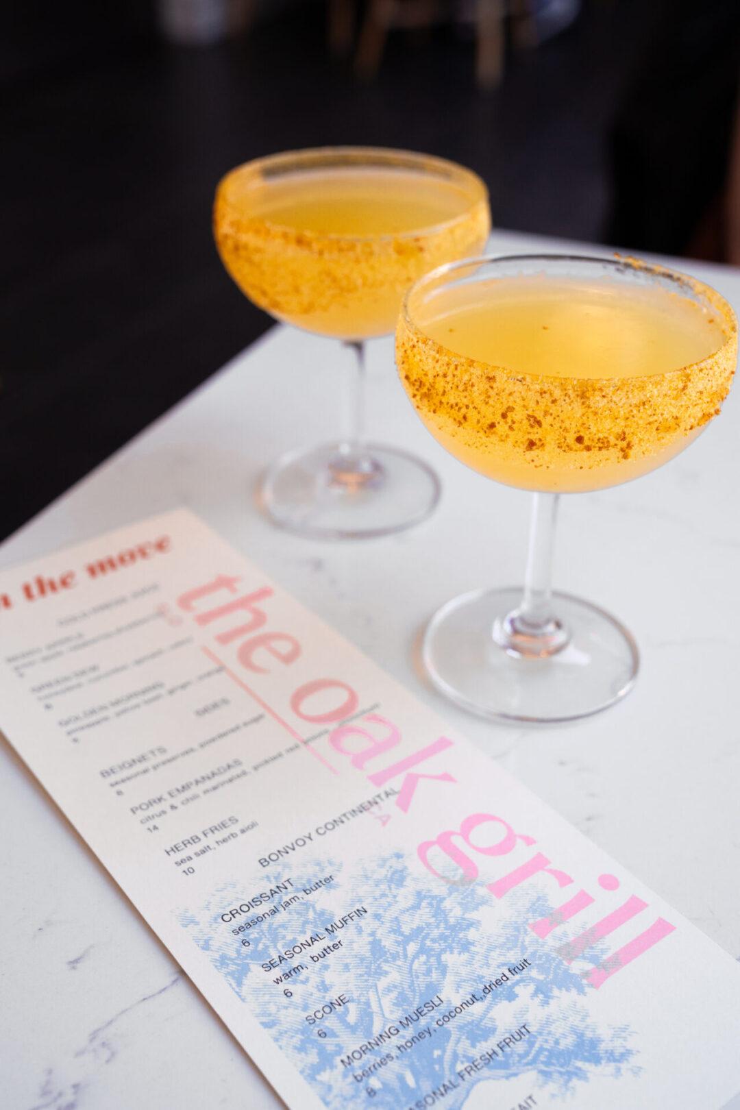 Two sugar-rimmed mimosas near a menu from The Oak Grill in Downtown San Luis Obispo, California