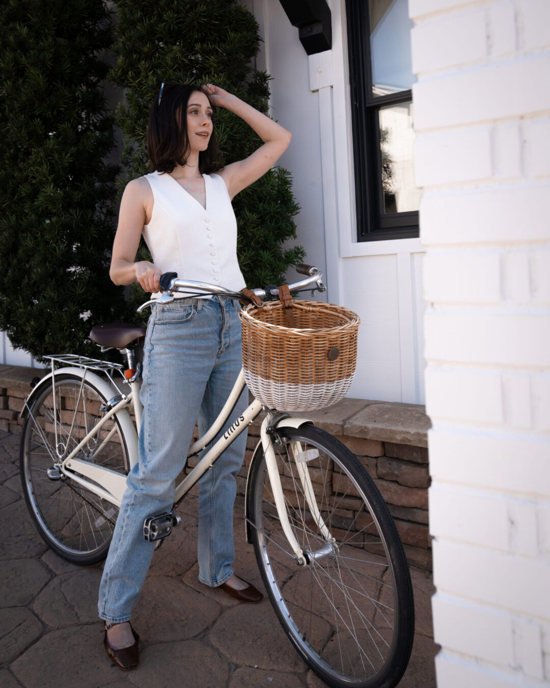 Travel Blogger Jordan Gassner getting ready to go on a bike ride along a cream beach cruiser from San Luis Creek Lodge in San Luis Obispo, California