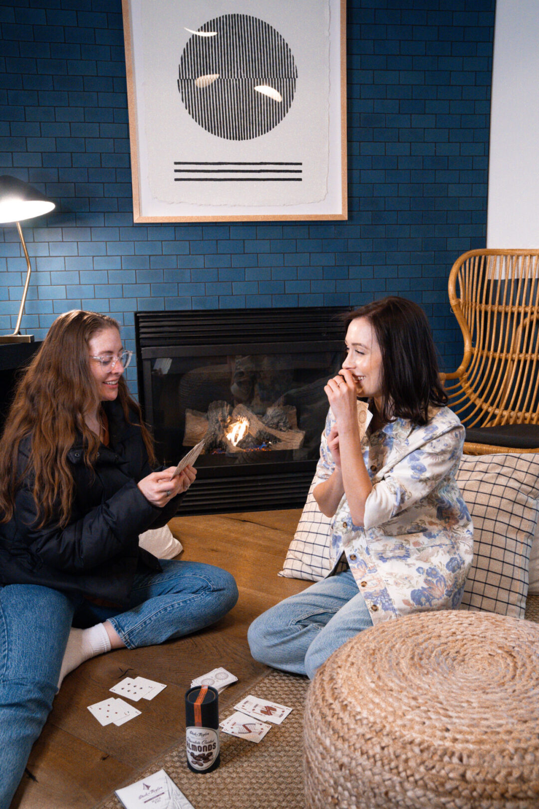 Travel Blogger Jordan Gassner playing cards with a friend inside a room by the fire at San Luis Creek Lodge in San Luis Obispo, California